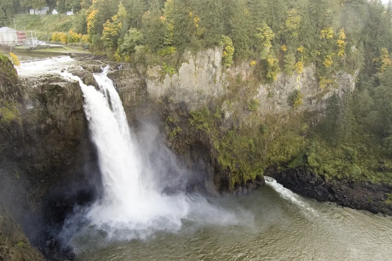 Snoqualmie Falls framed by yellow autumn leaves on the cliffs