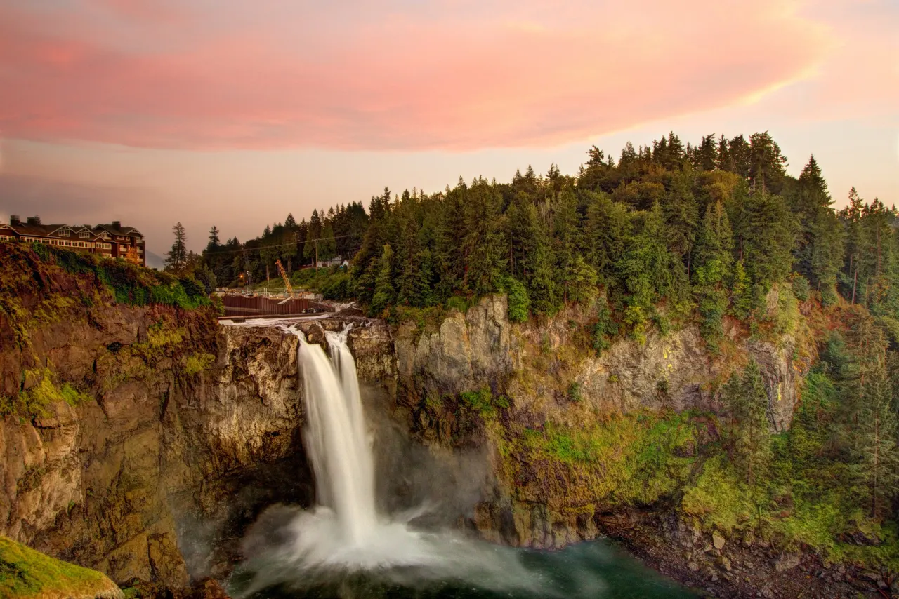 Salish Lodge on the cliff above the falls under a pink sunset sky