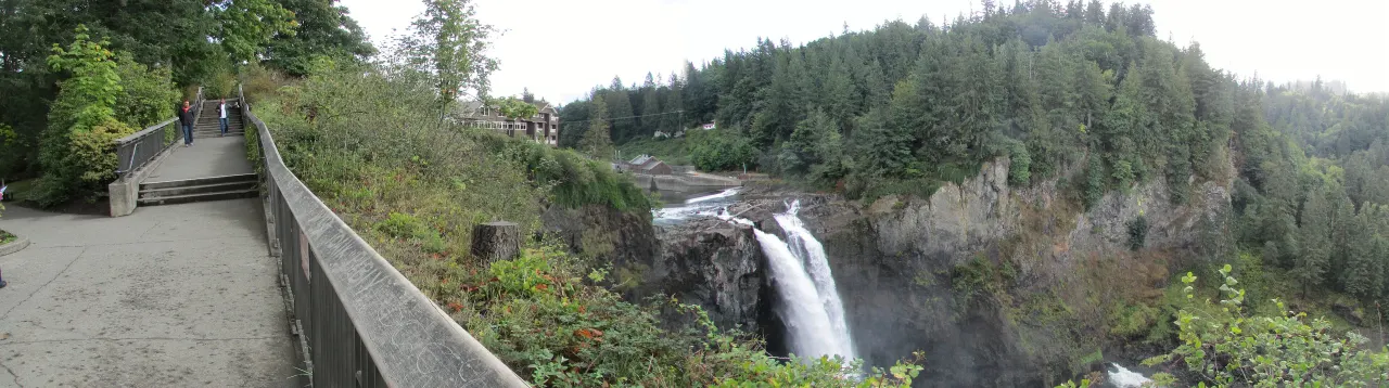 A wide panorama of the gorge, with the falls on the left and mist drifting over the river